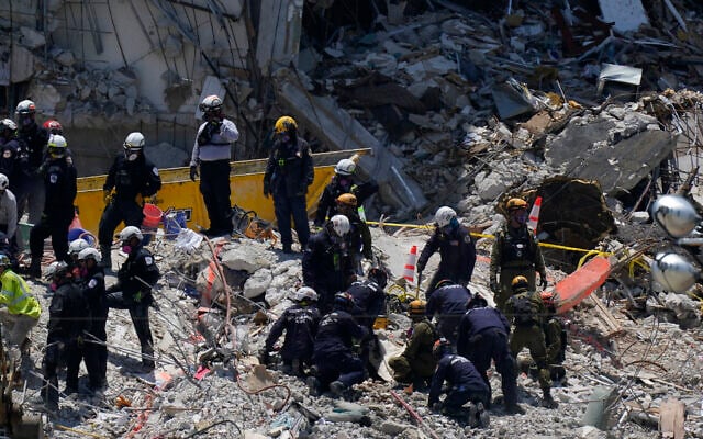 Search and rescue personnel work atop the rubble at the Champlain Towers South condo building, where scores of victims remain missing more than a week after it partially collapsed, on July 2, 2021, in Surfside, Florida. (AP Photo/Mark Humphrey) Search and rescue personnel work atop the rubble at the Champlain Towers South condo building, where scores of victims remain missing more than a week after it partially collapsed, on July 2, 2021, in Surfside, Florida. (AP Photo/Mark Humphrey)