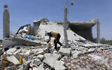 A civil defense worker inspects a destroyed building after shelling hit the town of Ibleen, a village in southern Idlib province, Syria, July 3, 2021. (AP Photo/Ghaith Alsayed)