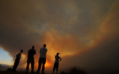 Residents of villages watch a fire in the Larnaca mountain region in Cyprus on July 3, 2021. (AP Photo/Petros Karadjias)