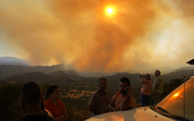 Residents of villages watch a fire in the Larnaca mountain region on July 3, 2021. (AP Photo/Petros Karadjias)