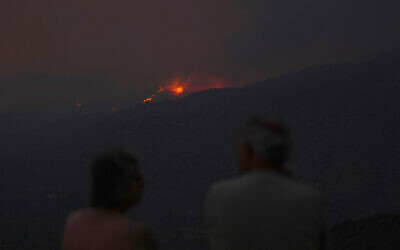 Residents of a village watch a fire in the Larnaca mountain region, Cyprus, July 3, 2021. (AP Photo/Petros Karadjias)