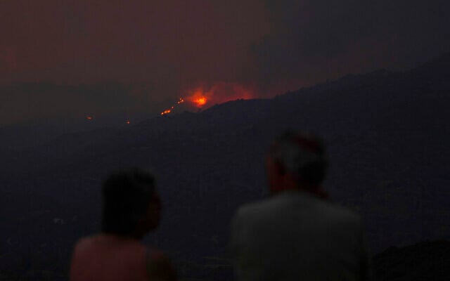 Residents of a village watch a fire in the Larnaca mountain region, Cyprus, July 3, 2021. (AP Photo/Petros Karadjias) Residents of a village watch a fire in the Larnaca mountain region, Cyprus, July 3, 2021. (AP Photo/Petros Karadjias)