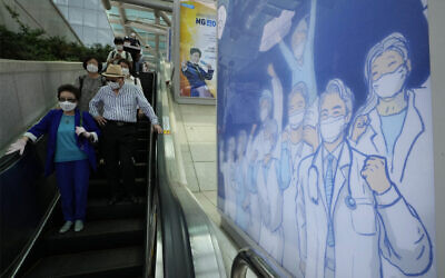 A poster hoping to overcome the COVID-19 crisis is displayed at a train station in Seoul, South Korea, Tuesday, July 6, 2021. (AP/Ahn Young-joon)