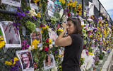 Gini Gonte visits the Surfside Wall of Hope Memorial on Wednesday, July 7, 2021, as she honors her friends Nancy Kress Levin and Jay Kleiman, who lost their lives after the collapse of the Champlain Towers South in Surfside, Fla. (Al Diaz/Miami Herald via AP)