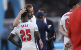 England's Harry Kane, center, consoles Bukayo Saka after the penalty shootout of the Euro 2020 soccer final match between England and Italy at Wembley stadium in London, July 11, 2021. (Laurence Griffiths/Pool via AP)