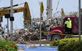 A worker waits to load his truck with debris from the rubble of the Champlain Towers South building, as removal and recovery work continues at the site of the partially collapsed condo building on July 14, 2021, in Surfside, Florida. (AP Photo/Lynne Sladky)