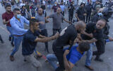 Plainclothes Palestinian security officers detain a protester during clashes that erupted during a demonstration against the death of Nizar Banat, a critic of the Palestinian Authority, in the West Bank city of Ramallah, on June 26, 2021. (AP Photo/Nasser Nasser)