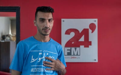 Palestinian journalist Akil Awawdeh at his office in the West Bank city of Ramallah, Wednesday, July 14, 2021. (AP Photo/Nasser Nasser)