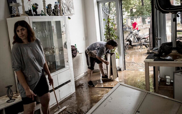 Homeowners push mud and water out of their house after flooding in Angleur, Province of Liege, Belgium, July 16, 2021 (AP Photo/Valentin Bianchi)
