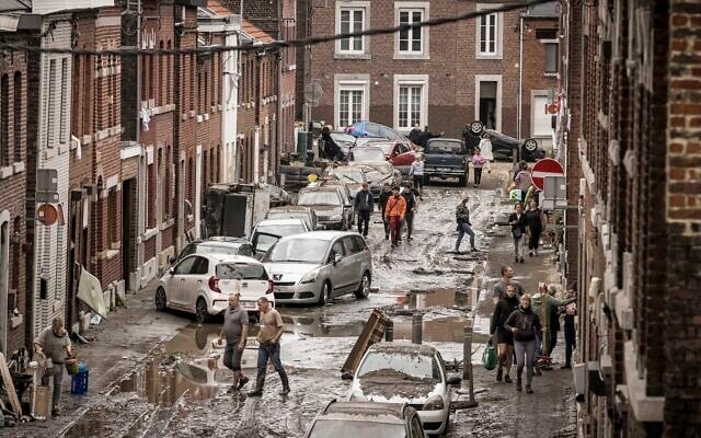 People walk through a damaged street after flooding in Chenee, Province of Liege, Belgium, July 16, 2021 (AP Photo/Valentin Bianchi) People walk through a damaged street after flooding in Chenee, Province of Liege, Belgium, July 16, 2021 (AP Photo/Valentin Bianchi)