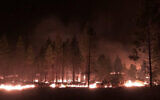 In this photo provided by the Bootleg Fire Incident Command, the Bootleg Fire burns at night near Highway 34 in southern Oregon on July 15, 2021 (Jason Pettigrew/Bootleg Fire Incident Command via AP)