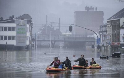 People use rubber rafts in floodwaters after the Meuse River broke its banks during heavy flooding in Liege, Belgium, July 15, 2021 (AP Photo/Valentin Bianchi)