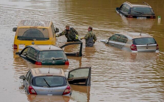 Rescuers check for victims in flooded cars on a road in Erftstadt, Germany, July 17, 2021 (AP/Michael Probst) Rescuers check for victims in flooded cars on a road in Erftstadt, Germany, July 17, 2021 (AP/Michael Probst)