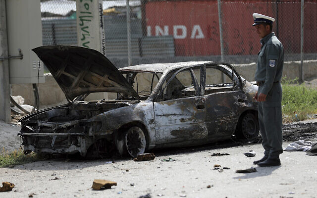 Afghan traffic police stand near a damaged vehicle where rockets were fired from in Kabul, Afghanistan, July 20, 2021. (Rahmat Gul/AP) Afghan traffic police stand near a damaged vehicle where rockets were fired from in Kabul, Afghanistan, July 20, 2021. (Rahmat Gul/AP)