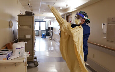 In this April 21, 2021, photo, a man dons protective gear before entering a room at a hospital in Royal Oak, Michigan (AP Photo/Carlos Osorio, File) In this April 21, 2021, photo, a man dons protective gear before entering a room at a hospital in Royal Oak, Michigan (AP Photo/Carlos Osorio, File)