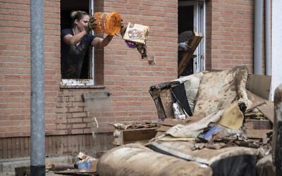 A woman throws rubbish from the window of her home onto a pile of discarded goods in the district of Blessem, in Ergfstadt, Germany, Thursday July 22, 2021. In the flood disaster area of Erftstadt-Blessem, some residents are being allowed back into their homes to clear debris after heavy rains caused devastating floods. (Marius Becker/dpa via AP) A woman throws rubbish from the window of her home onto a pile of discarded goods in the district of Blessem, in Ergfstadt, Germany, Thursday July 22, 2021. In the flood disaster area of Erftstadt-Blessem, some residents are being allowed back into their homes to clear debris after heavy rains caused devastating floods. (Marius Becker/dpa via AP)