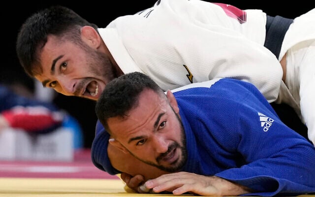 Vazha Margvelashvili of Georgia, top, and Baruch Shmailov of Israel compete during their men's -66kg quarterfinal judo match at the 2020 Summer Olympics, July 25, 2021, in Tokyo, Japan. (AP Photo/Vincent Thian) Vazha Margvelashvili of Georgia, top, and Baruch Shmailov of Israel compete during their men's -66kg quarterfinal judo match at the 2020 Summer Olympics, July 25, 2021, in Tokyo, Japan. (AP Photo/Vincent Thian)