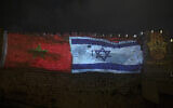 The national flags of Israel and Morocco are projected on the walls of the Old City of Jerusalem, along with the word "peace," in English, Hebrew, and Arabic, on December 23, 2020. (AP Photo/Maya Alleruzzo, File)