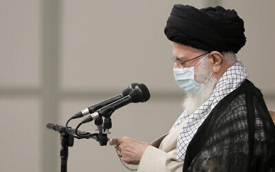In this photo released by an official website of the office of the Iranian supreme leader, Supreme Leader Ayatollah Ali Khamenei checks the time in farewell meeting with outgoing President Hassan Rouhani's administration in Tehran, Iran, in July 28, 2021. (Office of the Iranian Supreme Leader via AP)