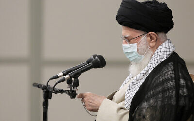 In this photo released by an official website of the office of the Iranian supreme leader, Supreme Leader Ayatollah Ali Khamenei checks the time in farewell meeting with outgoing President Hassan Rouhani's administration in Tehran, Iran, Wednesday, July 28, 2021. (Office of the Iranian Supreme Leader via AP)