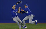 Israel's Mitchell Glasser (22) collides with teammate Blake Gailen as he catches a fly out hit by South Korea's Jaeil Oh during a baseball game at the 2020 Summer Olympics, July 29, 2021, in Yokohama, Japan. (AP Photo/Sue Ogrocki)