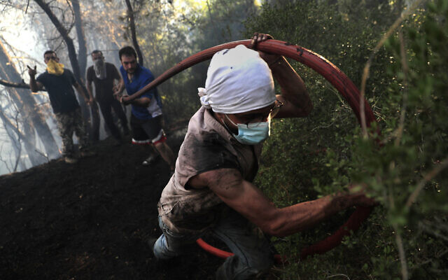 Civil defense workers extinguish a forest fire, at Qobayat village, in the northern Akkar province, Lebanon, on Thursday, July 29, 2021. (AP Photo/Hussein Malla) Civil defense workers extinguish a forest fire, at Qobayat village, in the northern Akkar province, Lebanon, on Thursday, July 29, 2021. (AP Photo/Hussein Malla)