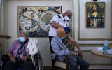 A man receives his second Pfizer-BioNTech COVID-19 vaccine from a Magen David Adom national emergency service volunteer, at a private nursing home in Ramat Gan, on January 13, 2021. (AP Photo/Oded Balilty)