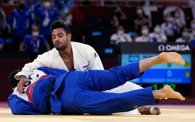 Sagi Muki of Israel, top, and Mikhail Igolnikov of the Russian Olympic Committee compete during their bronze medal match in team judo competition at the 2020 Summer Olympics, on July 31, 2021, in Tokyo, Japan. (AP Photo/Vincent Thian) Sagi Muki of Israel, top, and Mikhail Igolnikov of the Russian Olympic Committee compete during their bronze medal match in team judo competition at the 2020 Summer Olympics, on July 31, 2021, in Tokyo, Japan. (AP Photo/Vincent Thian)