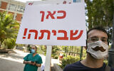Illustrative: A man with a sign reading "strike here!" takes part in a strike of nurses at Hadassah Hospital in Jerusalem on July 20, 2020. (Olivier Fitoussi/Flash90)