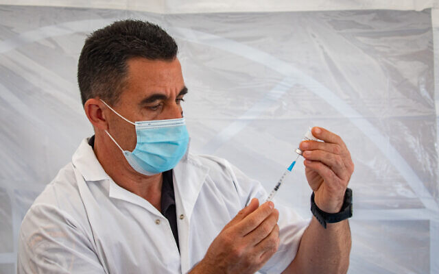 An Israeli medical worker prepares a coronavirus vaccine (Olivier Fitoussi/Flash90) An Israeli medical worker prepares a coronavirus vaccine (Olivier Fitoussi/Flash90)