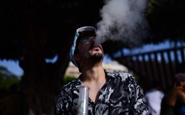An Israeli man smokes marijuana at Rabin Square in Tel Aviv during a demonstration calling to legalize cannabis, on April 20, 2021. (Tomer Neuberg/Flash90) An Israeli man smokes marijuana at Rabin Square in Tel Aviv during a demonstration calling to legalize cannabis, on April 20, 2021. (Tomer Neuberg/Flash90)