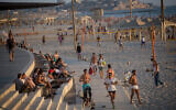 Illustrative: Israelis enjoy the beach in Tel Aviv on a hot summer day, on July 6, 2021. (Miriam Alster/Flash90)
