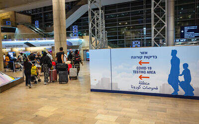 Travelers arriving at the Ben Gurion International Airport, stand in line to get a COVID-19 check upon arrival. July 1, 2021. (Nati Shohat/FLASH90)
