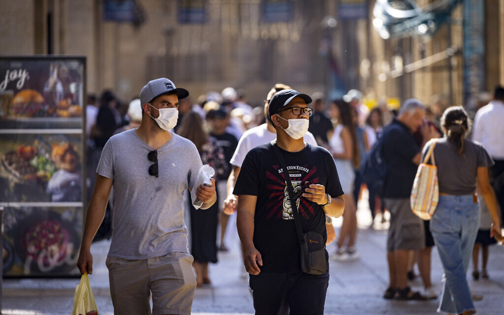 People, some wearing face masks, walk in Jerusalem on July 8, 2021. (Olivier Fitoussi/Flash90) People, some wearing face masks, walk in Jerusalem on July 8, 2021. (Olivier Fitoussi/Flash90)