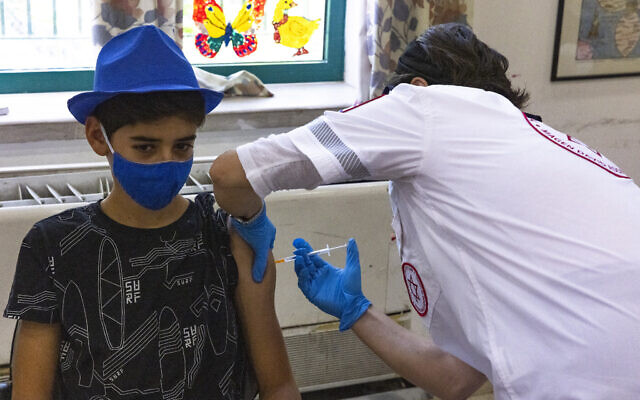 An Israeli youth receives the COVID-19 vaccine at a vaccination center of Magen David Adom in Jerusalem on July 8, 2021. (Olivier Fitoussi/Flash90) An Israeli youth receives the COVID-19 vaccine at a vaccination center of Magen David Adom in Jerusalem on July 8, 2021. (Olivier Fitoussi/Flash90)