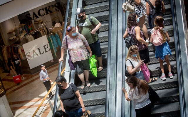 People wear protective face masks as they shop at Azrieli Mall in Tel Aviv on July 13, 2021. (Miriam Alster/FLASH90) People wear protective face masks as they shop at Azrieli Mall in Tel Aviv on July 13, 2021. (Miriam Alster/FLASH90)