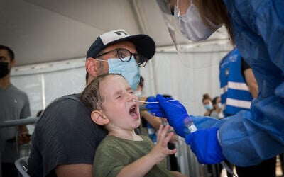 A technician collects swab samples for COVID-19 at a testing center run by the Tel Aviv municipality, on July 20, 2021. (Miriam Alster/Flash90)