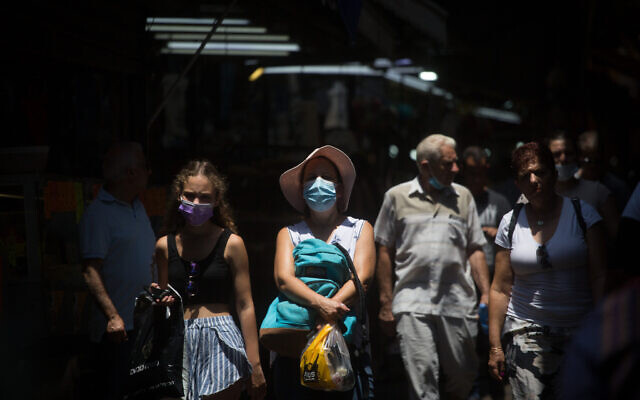 Israelis wear protective face masks as they walk through the Carmel market in Tel Aviv, on July 20, 2021. (Miriam Alster/FLASH90) Israelis wear protective face masks as they walk through the Carmel market in Tel Aviv, on July 20, 2021. (Miriam Alster/FLASH90)
