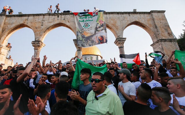 Worshippers raise the Palestinian flag and a Hamas banner following Eid al-Adha prayers on the Temple Mount, July 20, 2021. (Jamal Awad/Flash90) Worshippers raise the Palestinian flag and a Hamas banner following Eid al-Adha prayers on the Temple Mount, July 20, 2021. (Jamal Awad/Flash90)