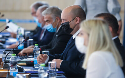 Prime Minister Naftali Bennett, center wearing black mask, during a cabinet meeting at the Foreign Ministry in Jerusalem on July 25, 2021. (Marc Israel Sellem/Pool)