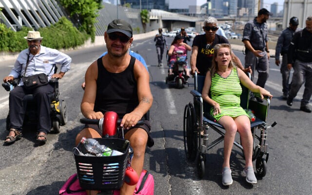 Disabled activists block the Ayalon Highway in Tel Aviv on July 25, 2021. (Tomer Neuberg/Flash90) Disabled activists block the Ayalon Highway in Tel Aviv on July 25, 2021. (Tomer Neuberg/Flash90)