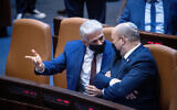 Yair Lapid, left, and Naftali Bennett seen during a plenary session at the Knesset in Jerusalem, on July 26, 2021. (Yonatan Sindel/Flash90)