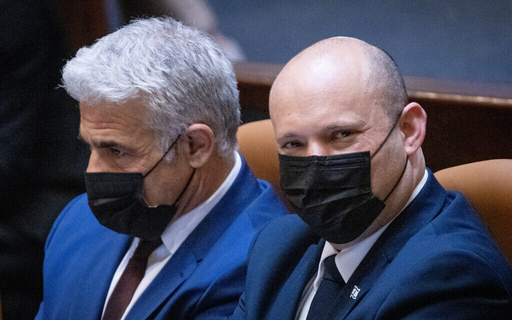 Foreign Minister Yair Lapid and Israeli Prime Minister Naftali Bennett seen during a plenary session at the assembly hall of the Knesset in Jerusalem, July 26, 2021. (Yonatan Sindel/Flash90)
