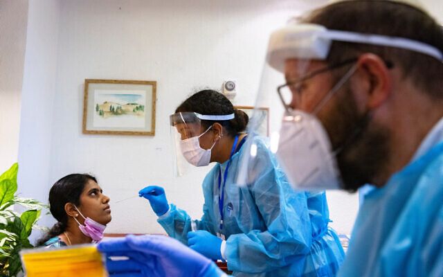 Health care workers take test samples from a caregiver a at Migdal Nofim retirement home in Jerusalem, July 27, 2021. (Olivier Fitoussi/Flash90) Health care workers take test samples from a caregiver a at Migdal Nofim retirement home in Jerusalem, July 27, 2021. (Olivier Fitoussi/Flash90)