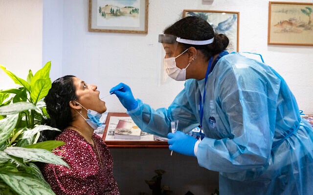 A medical worker performs coronavirus tests at a retirement home in Jerusalem on July 27, 2021. (Olivier Fitoussi/Flash90) A medical worker performs coronavirus tests at a retirement home in Jerusalem on July 27, 2021. (Olivier Fitoussi/Flash90)
