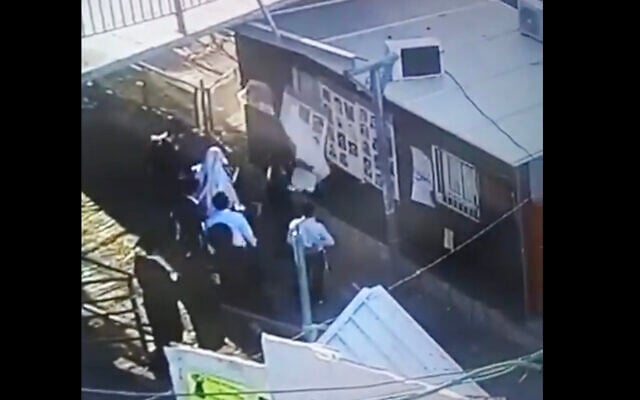 A screenshot of security camera footage shows suspects vandalizing posters of the victims of the Mount Meron disaster. (Screen capture: Twitter) A screenshot of security camera footage shows suspects vandalizing posters of the victims of the Mount Meron disaster. (Screen capture: Twitter)