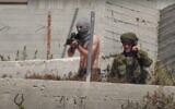 A photo distributed by B'Tselem showing an off-duty soldier with a shirt wrapped around his face as a mask opening fire toward the village of Urif from the Yitzhar settlement on May 14, 2021. (B'Tselem)