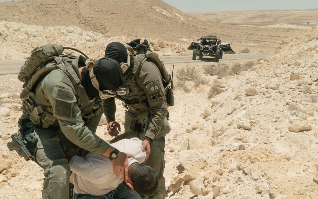 Israeli soldiers pretend to arrest a suspected smuggler during a simulation near the Egyptian border on July 8, 2021. (Israel Defense Forces) Israeli soldiers pretend to arrest a suspected smuggler during a simulation near the Egyptian border on July 8, 2021. (Israel Defense Forces)