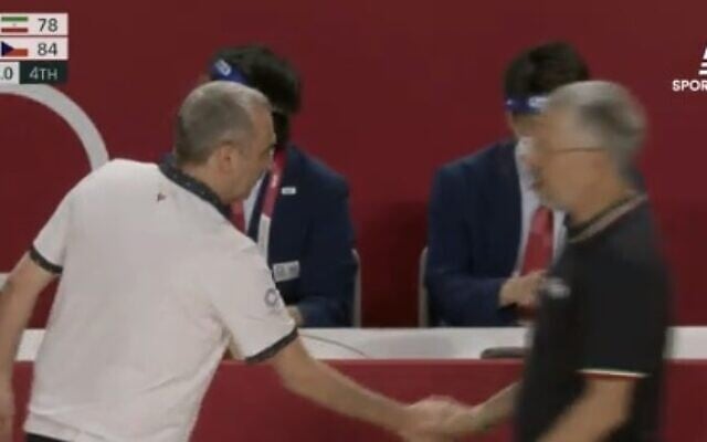 Ronen Ginzburg, the Israeli coach of the Czech national men's basketball team, shakes hands with his Iranian counterpart, Mehran Shahintab, at the Olympic Games on July 25, 2021 (Screen capture: Sports 5) Ronen Ginzburg, the Israeli coach of the Czech national men's basketball team, shakes hands with his Iranian counterpart, Mehran Shahintab, at the Olympic Games on July 25, 2021 (Screen capture: Sports 5)