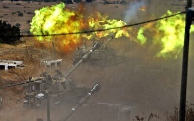Israeli self-propelled howitzers fire toward Lebanon from a position near the northern town of Kiryat Shmona following rocket fire by the Lebanese terror group Hezbollah, August 6, 2021. (Jalaa Marey/AFP)